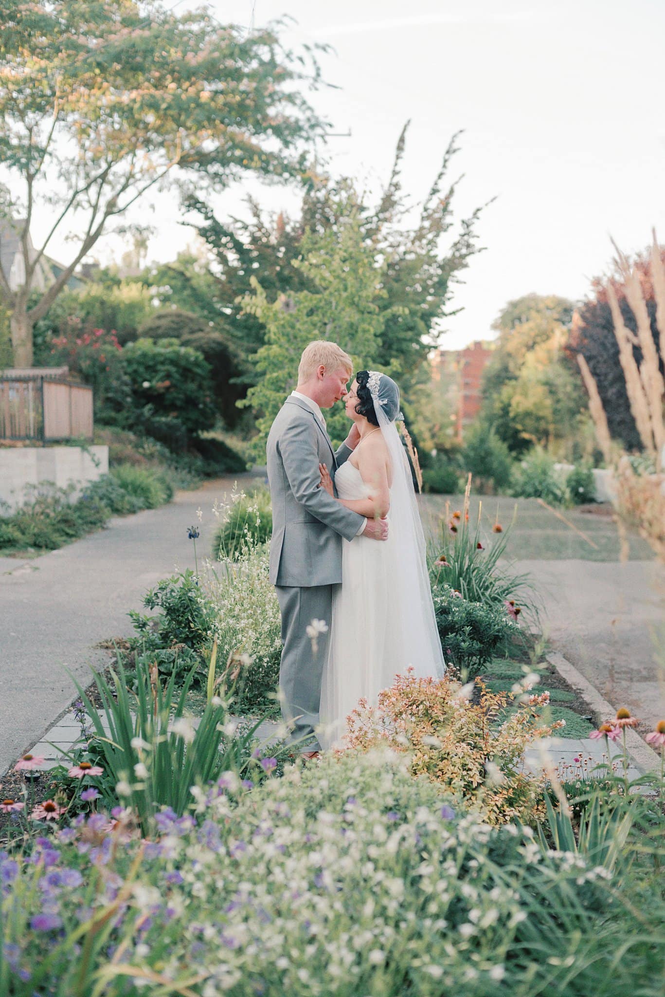 Newlyweds touch foreheads while standing in one of the garden wedding venues in washington