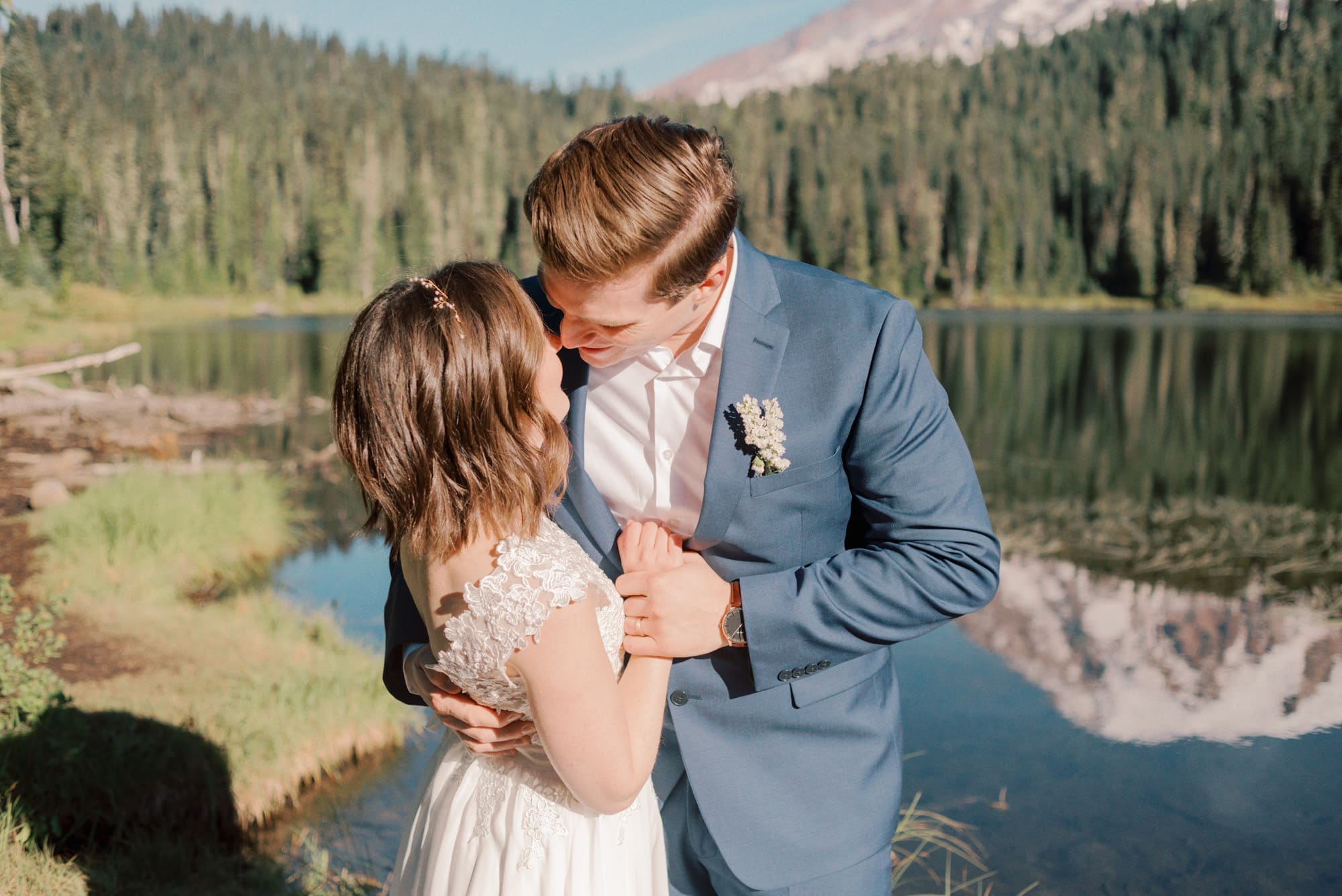 Newlyweds lean in for a kiss next to a lake at one of the amazing Olympia Wedding Venues